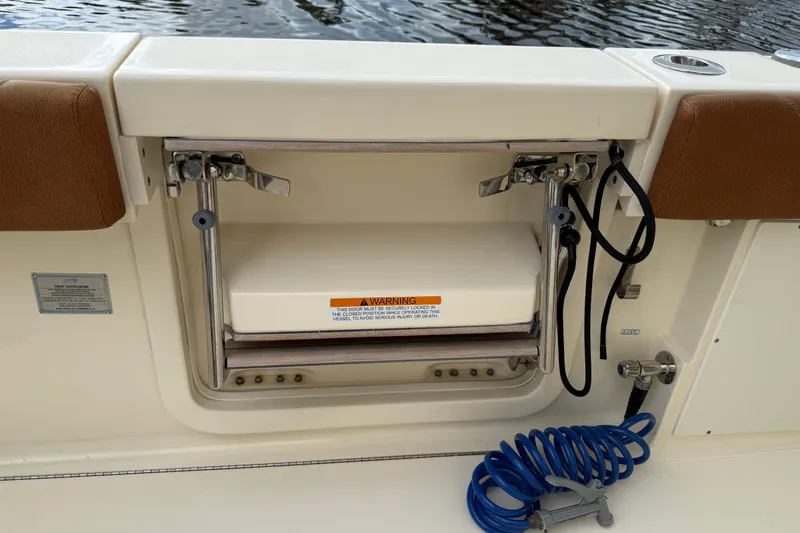 T/t B Happy Yacht Photos Pics 2019 Scout 320 LXF boat with open storage compartment and coiled blue hose.