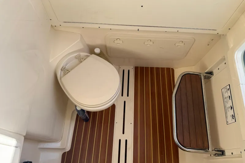 T/t B Happy Yacht Photos Pics 2019 Scout 320 LXF boat interior with toilet and wooden flooring.