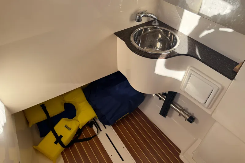 T/t B Happy Yacht Photos Pics 2019 Scout 320 LXF boat interior with sink, life jackets, and wooden flooring.