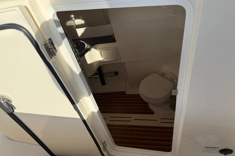 T/t B Happy Yacht Photos Pics 2019 Scout 320 LXF boat interior with compact bathroom and wooden flooring.