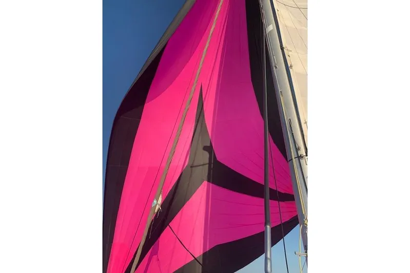  Yacht Photos Pics Vibrant pink and black sail on a 2017 Bali 4.0 catamaran against clear blue sky.