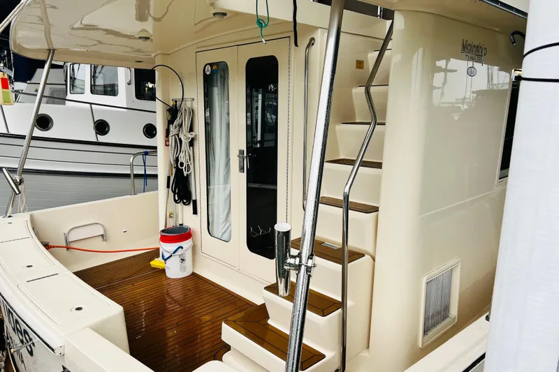 Tranquil Tides Yacht Photos Pics 2006 Mainship 34 Trawler with wooden deck, stairs, and nautical equipment.