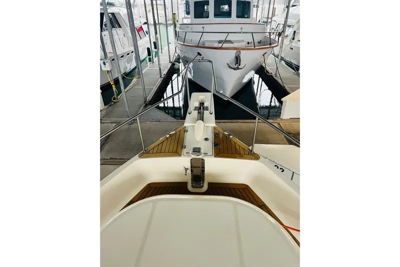 Tranquil Tides Yacht Photos Pics 2006 Mainship 34 Trawler docked in a marina, view from the bow.