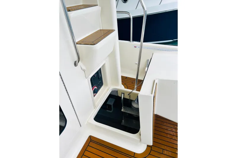 Tranquil Tides Yacht Photos Pics 2006 Mainship 34 Trawler interior with steps and control panel, featuring teak flooring.