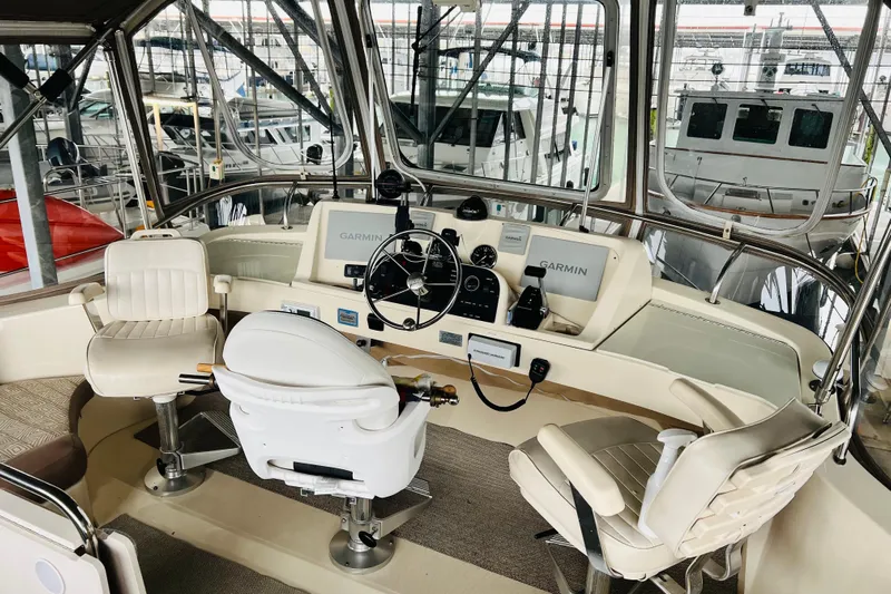 Tranquil Tides Yacht Photos Pics 2006 Mainship 34 Trawler helm with Garmin navigation, featuring comfortable seating and modern controls.