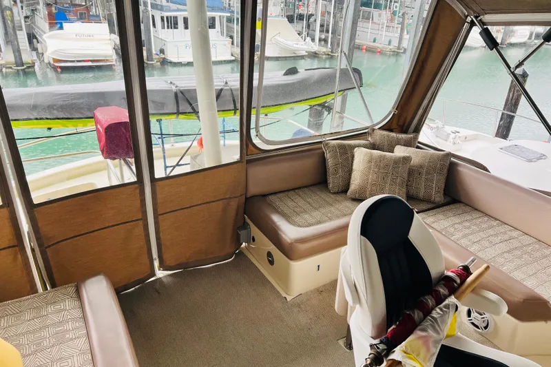 Tranquil Tides Yacht Photos Pics Interior of 2006 Mainship 34 Trawler with cushioned seating and marina view.