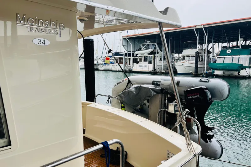 Tranquil Tides Yacht Photos Pics 2006 Mainship 34 Trawler docked with inflatable boat and Nissan Marine motor.