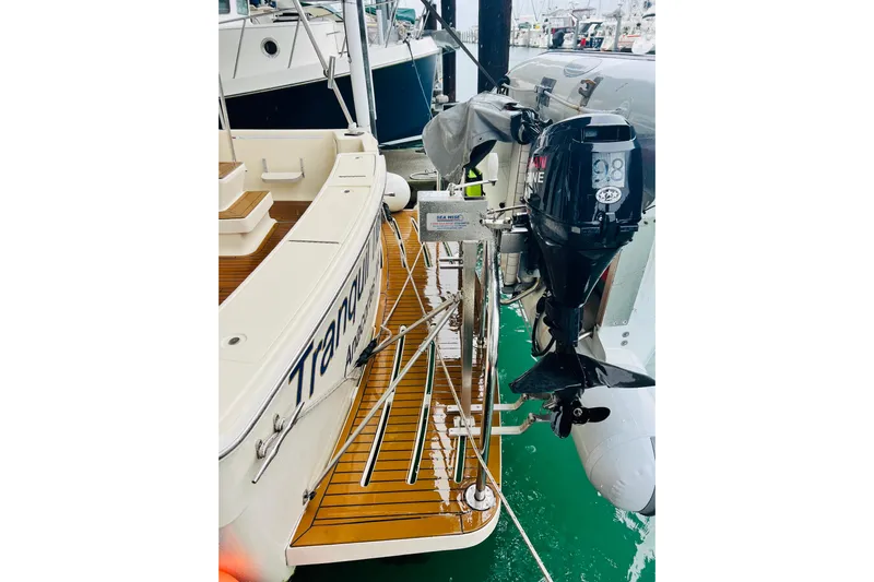 Tranquil Tides Yacht Photos Pics 2006 Mainship 34 Trawler with outboard motor, docked at marina.