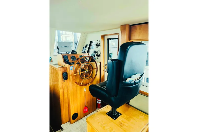 Tranquil Tides Yacht Photos Pics 2006 Mainship 34 Trawler helm with wooden wheel and Garmin navigation system.