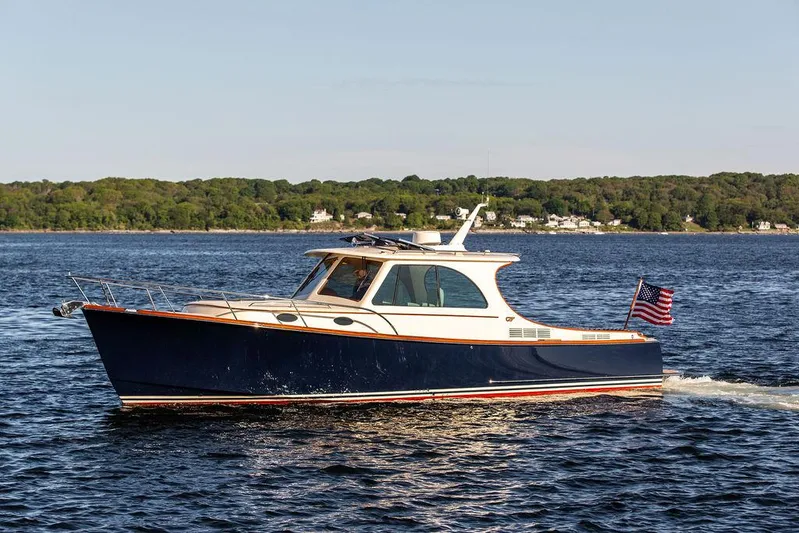 Brendan Yacht Photos Pics 2018 Hinckley Picnic Boat 37 MKIII cruising on a serene lake with lush green shoreline.
