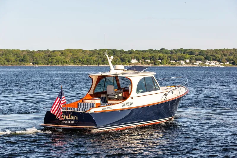 Brendan Yacht Photos Pics 2018 Hinckley Picnic Boat 37 MKIII cruising on a serene lake with American flag.
