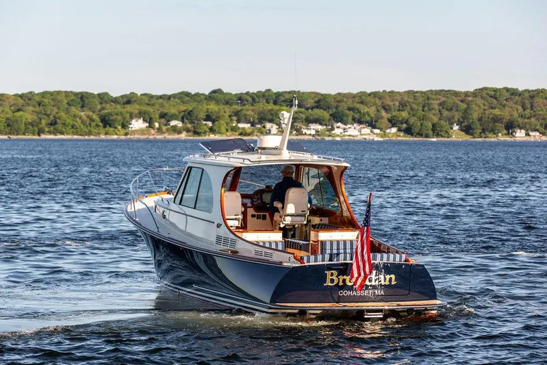 Brendan Yacht Photos Pics 2018 Hinckley Picnic Boat 37 MKIII cruising on a scenic lake with lush green shoreline.