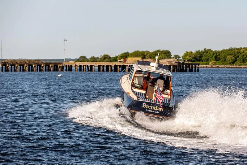 Brendan Yacht Photos Pics Hinckley Picnic Boat 37 MKIII cruising on water, 2018 model, with American flag.