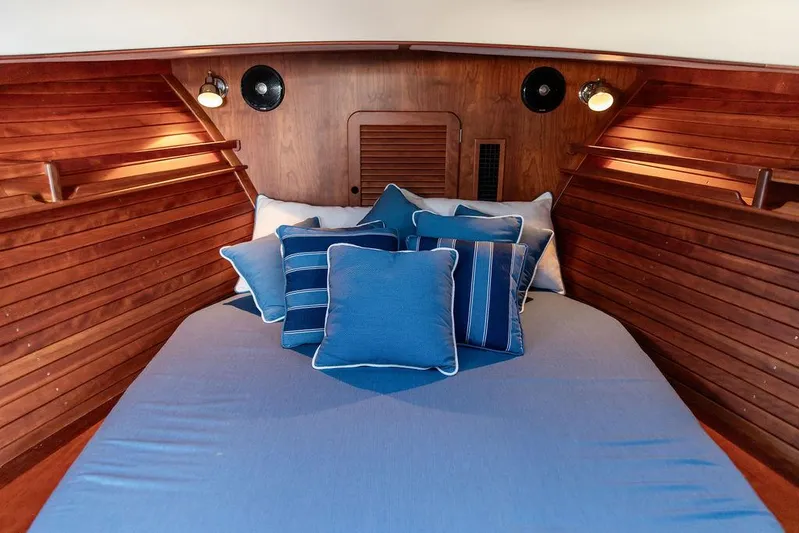 Brendan Yacht Photos Pics Cozy cabin interior of 2018 Hinckley Picnic Boat 37 MKIII with blue bedding and wooden paneling.