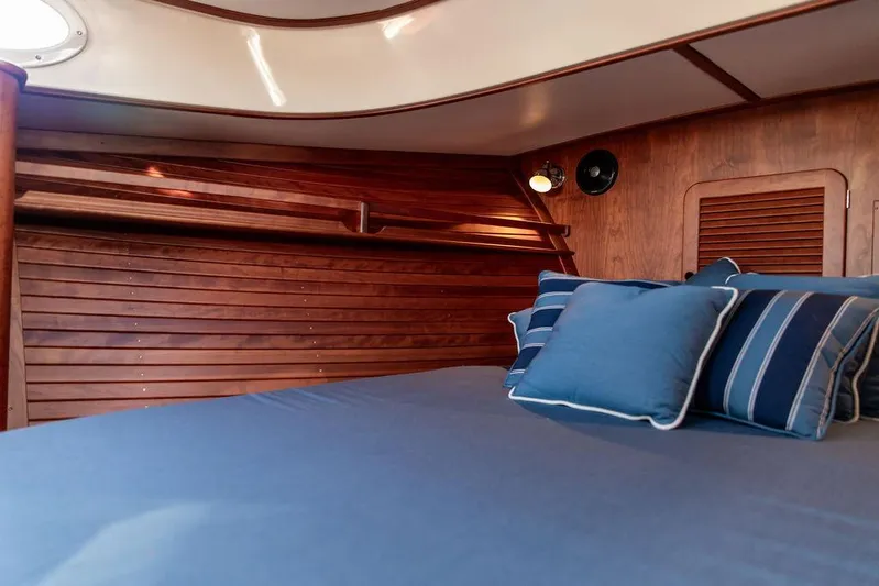 Brendan Yacht Photos Pics Cabin interior of 2018 Hinckley Picnic Boat 37 MKIII with blue bedding and wooden paneling.