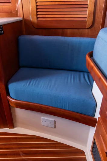 Brendan Yacht Photos Pics 2018 Hinckley Picnic Boat 37 MKIII interior with blue cushioned seating and wooden accents.