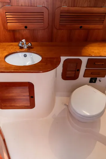 Brendan Yacht Photos Pics 2018 Hinckley Picnic Boat 37 MKIII bathroom with wooden cabinetry and modern fixtures.