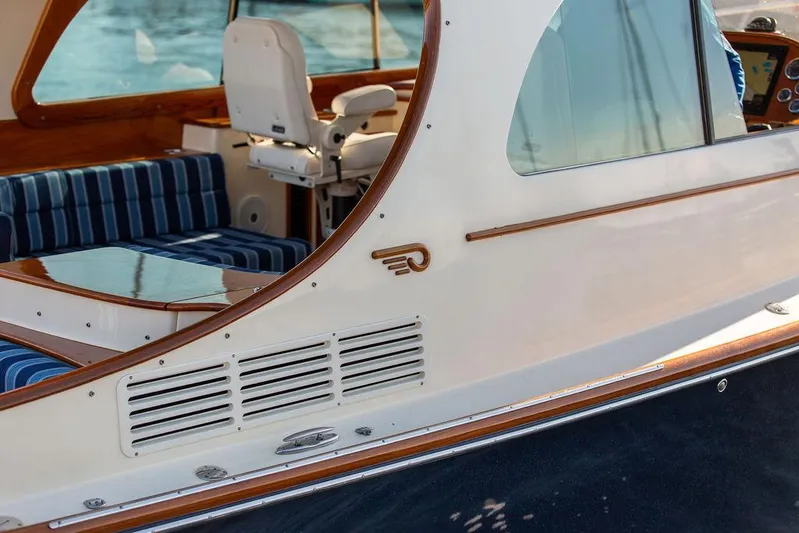 Brendan Yacht Photos Pics 2018 Hinckley Picnic Boat 37 MKIII, elegant design with striped seating and wooden accents.