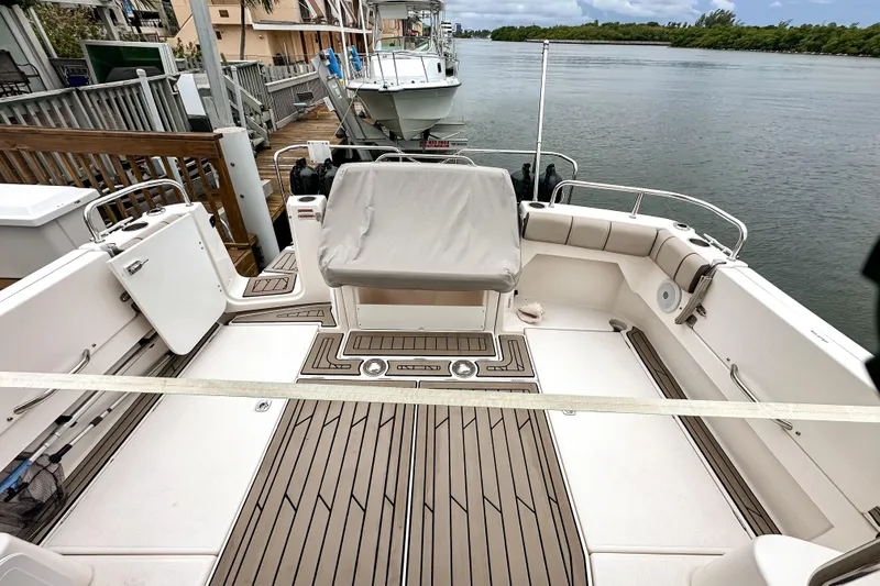  Yacht Photos Pics 2022 Cutwater 30 Command Bridge boat with spacious deck and seating, docked by the water.