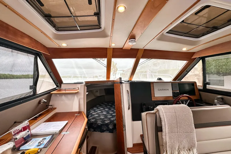  Yacht Photos Pics Interior of 2022 Cutwater 30 Command Bridge with navigation equipment and cozy seating.