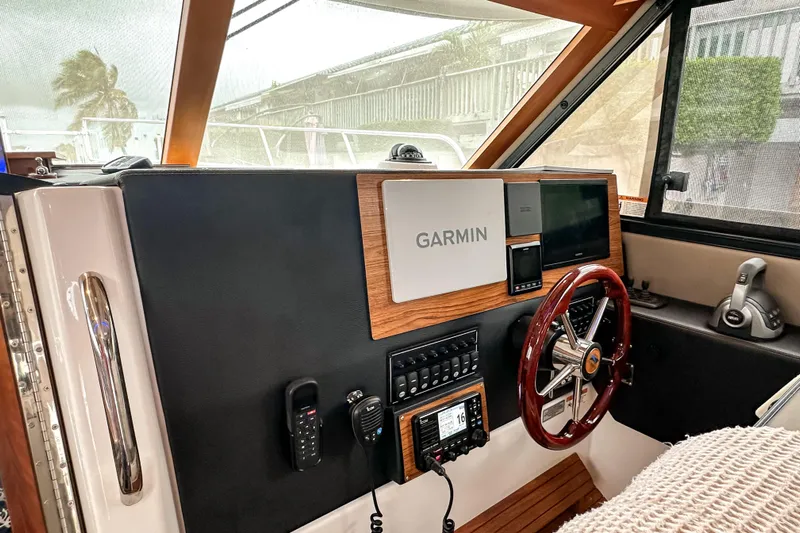  Yacht Photos Pics 2022 Cutwater 30 Command Bridge helm with Garmin navigation, wood accents, and modern controls.