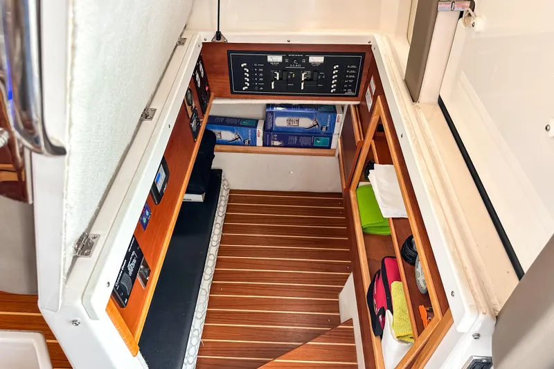  Yacht Photos Pics 2022 Cutwater 30 Command Bridge interior storage with control panel and wooden flooring.