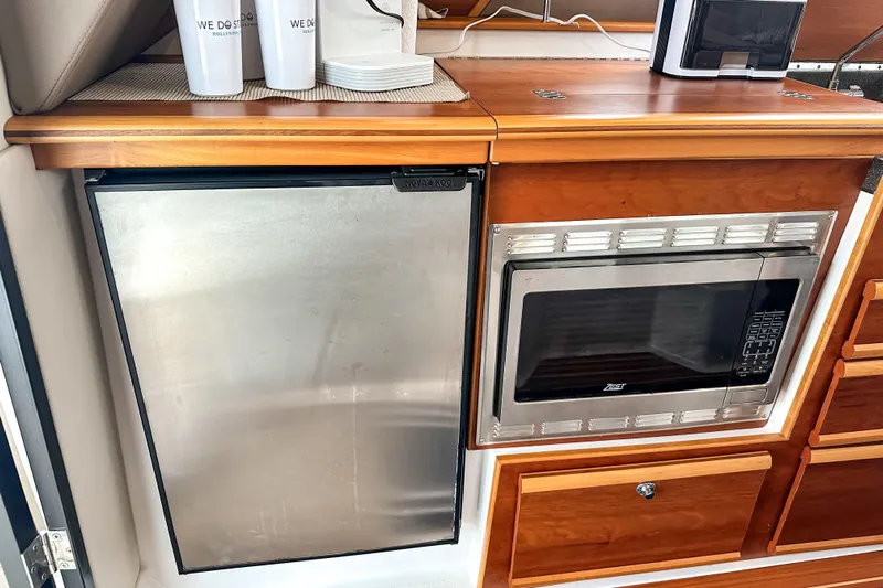  Yacht Photos Pics 2022 Cutwater 30 Command Bridge galley with stainless steel fridge and microwave.