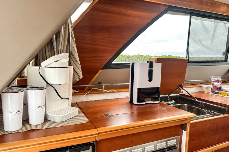  Yacht Photos Pics 2022 Cutwater 30 Command Bridge kitchen with appliances and wooden cabinetry.