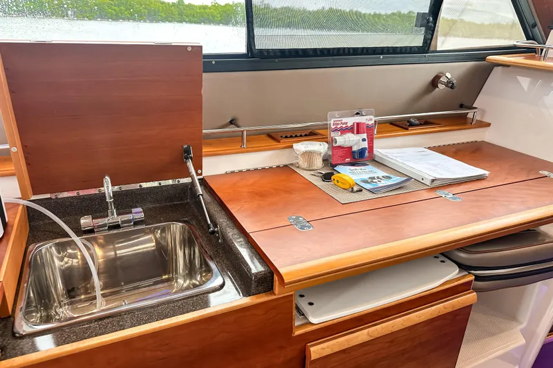  Yacht Photos Pics 2022 Cutwater 30 Command Bridge interior with sink, wooden countertop, and accessories.