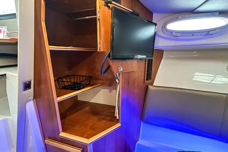  Yacht Photos Pics 2022 Cutwater 30 Command Bridge interior with TV, wooden shelves, and seating area.
