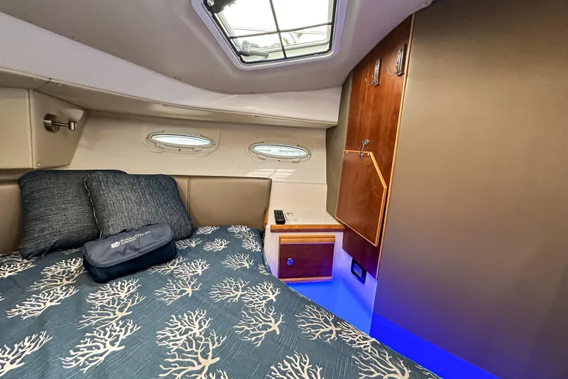  Yacht Photos Pics Cozy cabin interior of 2022 Cutwater 30 Command Bridge with elegant bedding and wood accents.