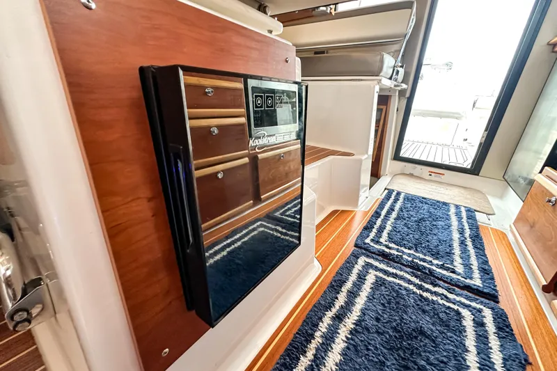  Yacht Photos Pics 2022 Cutwater 30 Command Bridge interior with wood accents and blue rug.