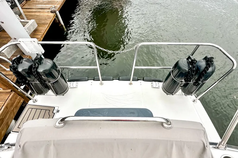  Yacht Photos Pics 2022 Cutwater 30 Command Bridge boat stern with fenders, docked by wooden pier.