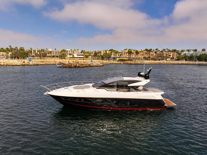 Veni Vici Yacht Photos Pics 2019 Sunseeker Predator 57 yacht cruising in a scenic harbor under a partly cloudy sky.