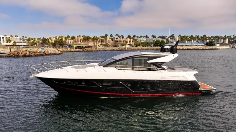 Veni Vici Yacht Photos Pics 2019 Sunseeker Predator 57 yacht on calm water, with coastal cityscape background.