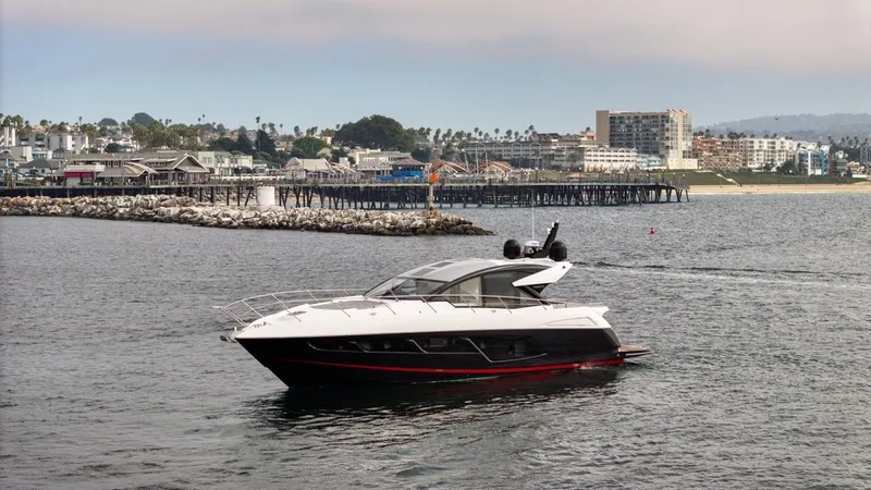Veni Vici Yacht Photos Pics 2019 Sunseeker Predator 57 yacht cruising near a coastal pier and cityscape.