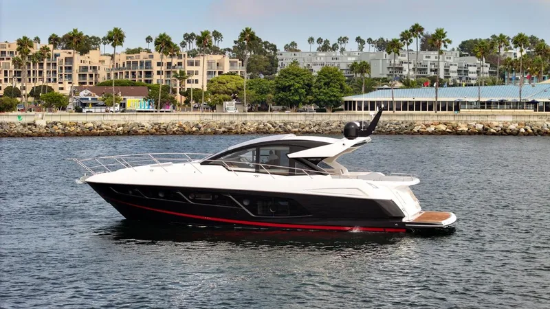 Veni Vici Yacht Photos Pics 2019 Sunseeker Predator 57 yacht cruising near a coastal cityscape.