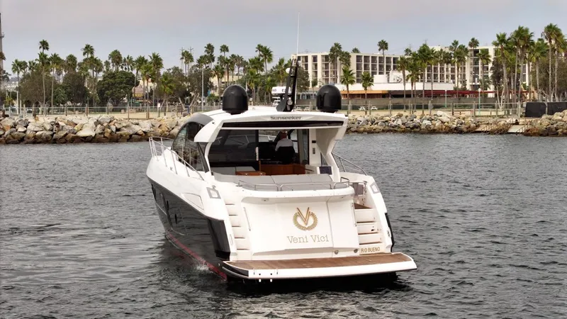 Veni Vici Yacht Photos Pics 2019 Sunseeker Predator 57 yacht cruising near a coastal cityscape.