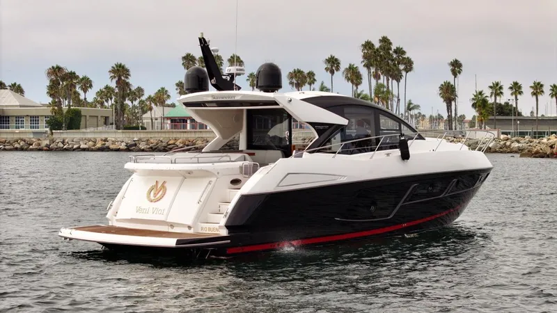 Veni Vici Yacht Photos Pics 2019 Sunseeker Predator 57 yacht cruising near palm-lined shore.