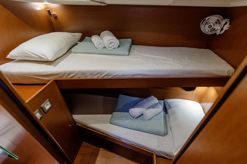  Yacht Photos Pics 2019 Beneteau Oceanis 51.1 yacht cabin with bunk beds and cozy lighting.