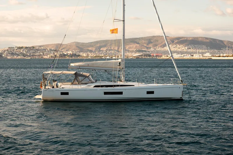  Yacht Photos Pics 2019 Beneteau Oceanis 51.1 sailboat on calm waters with scenic coastal backdrop.