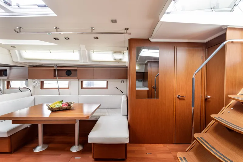  Yacht Photos Pics Luxurious interior of 2019 Beneteau Oceanis 51.1 yacht with wooden finishes and seating area.