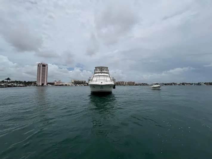 Seas The Day Yacht Photos Pics 2000 Silverton 453 Motor Yacht on calm water with cityscape background.