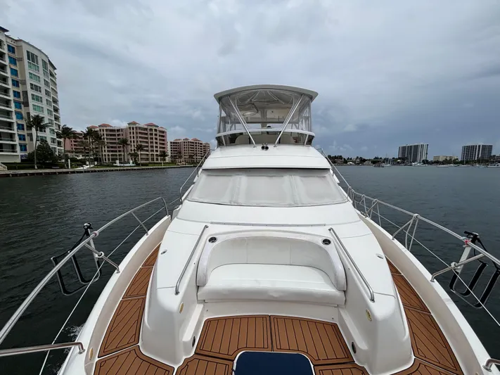 Seas The Day Yacht Photos Pics 2000 Silverton 453 Motor Yacht on water, surrounded by modern buildings.