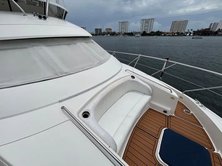 Seas The Day Yacht Photos Pics 2000 Silverton 453 Motor Yacht deck with seating, overlooking waterfront skyline.