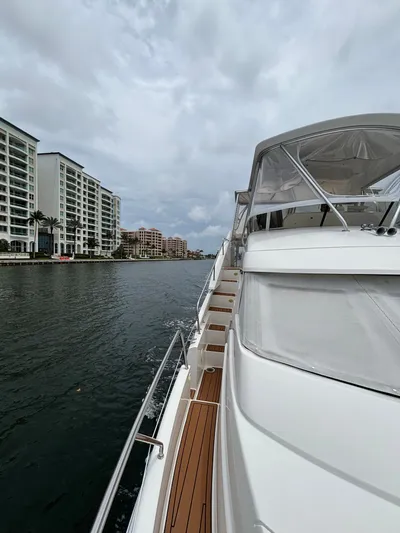 Seas The Day Yacht Photos Pics 2000 Silverton 453 Motor Yacht cruising near waterfront buildings under cloudy skies.