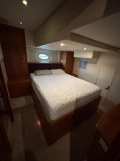 Seas The Day Yacht Photos Pics Interior of 2000 Silverton 453 Motor Yacht bedroom with bed and porthole window.