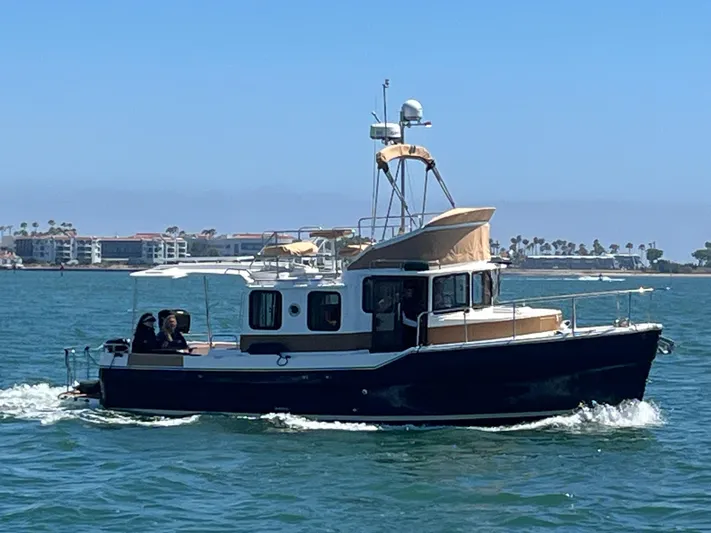 Together Again II Yacht Photos Pics 2022 Ranger Tugs R-31 CB cruising on a sunny day near coastal buildings.