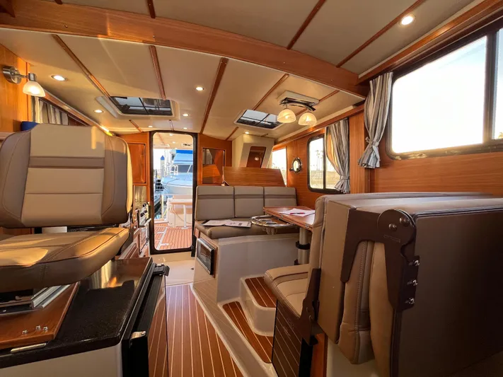 Together Again II Yacht Photos Pics Interior of 2022 Ranger Tugs R-31 CB, featuring elegant wood finishes and modern seating.