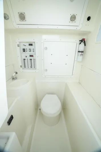  Yacht Photos Pics 2013 SeaVee 390B boat bathroom with toilet, control panel, and fire extinguisher.